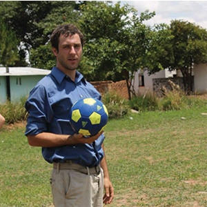 Brad Soccer Brad posing outside holding a soccer ball.