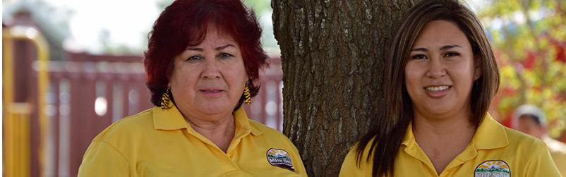 Two MHP Salud Community Health Workers pose in a park.