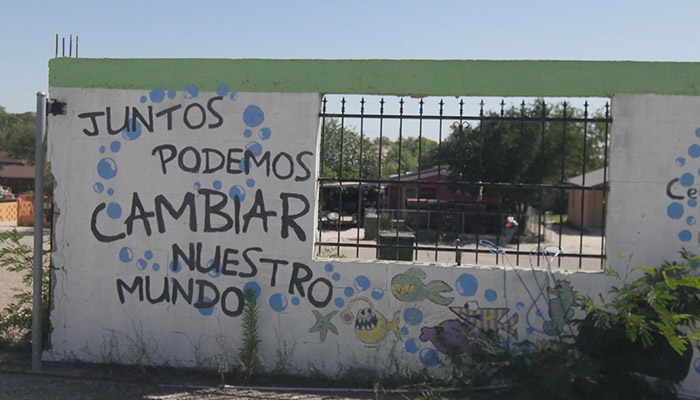 A wall with the words "Juntos podemos cambiar nuestro mundo".