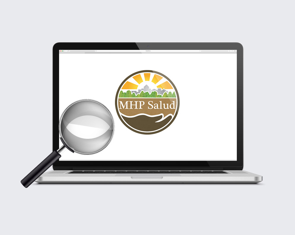 A magnifying glass on a laptop with MHP Salud's logo.