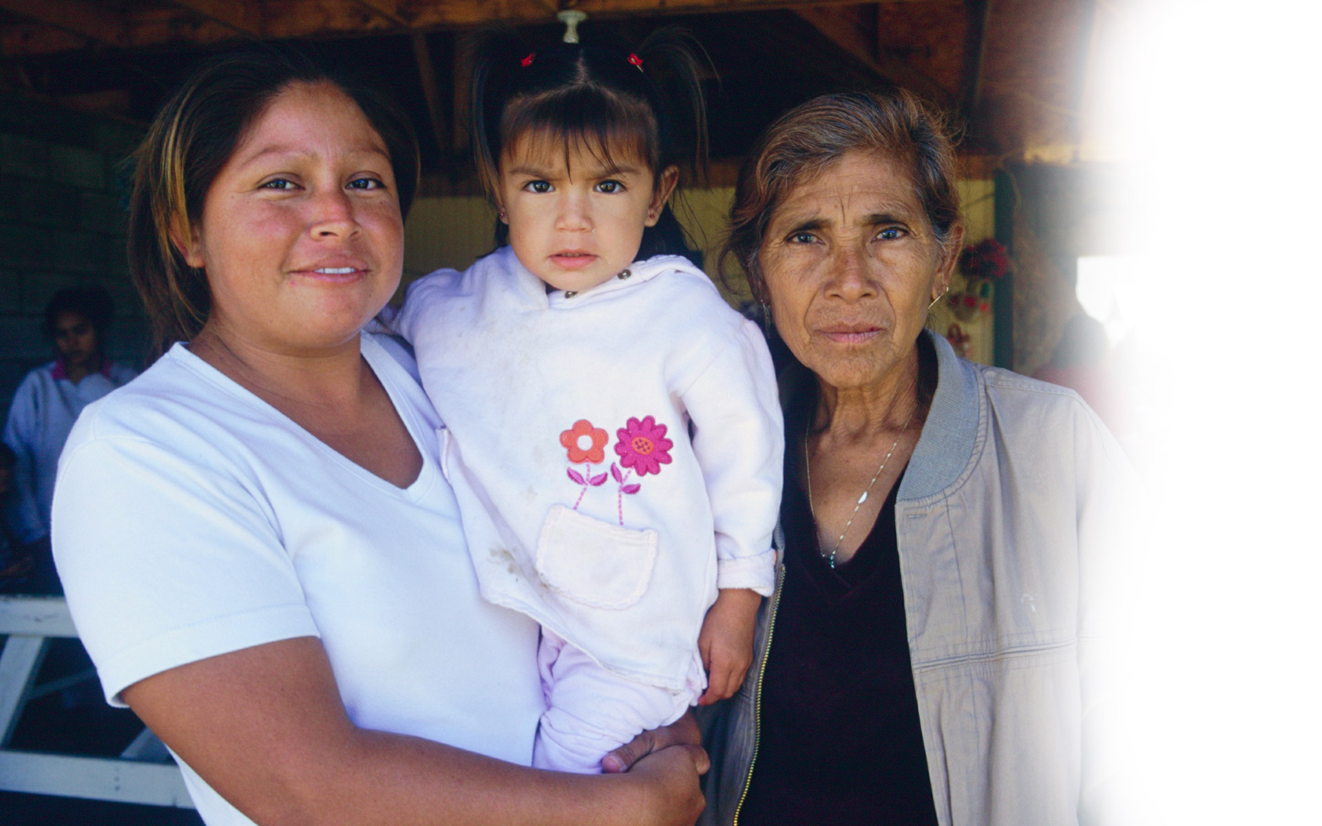 Who we Serve A mother and grandmother holding a child.