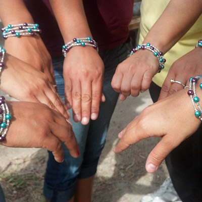 Women wearing hand-made bracelets.