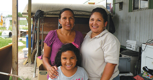 Promotora posing with a mother and her daughter