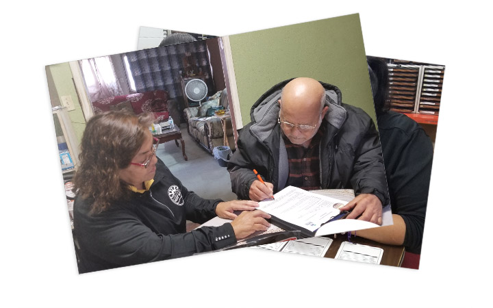 An MHP Salud CHW helping a man with an application.